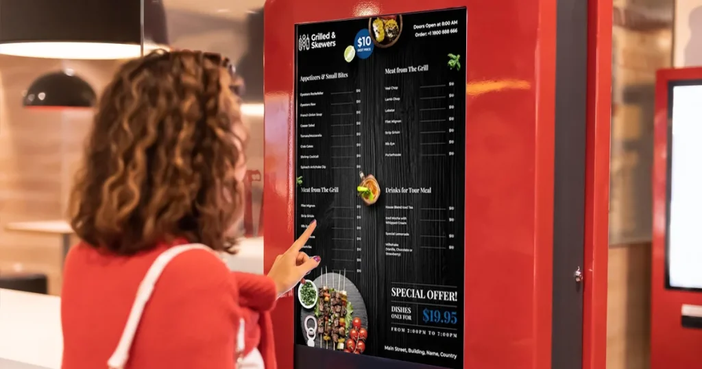 Woman self ordering from kiosk