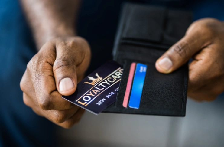 a man pulling a loyalty card from a wallet