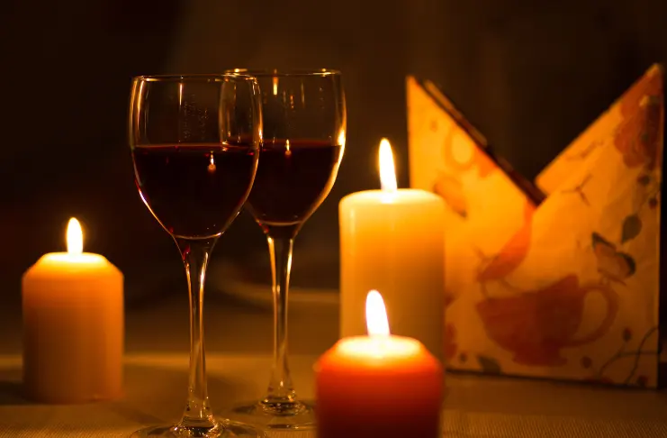 3 candles and 2 wine glasses on a table