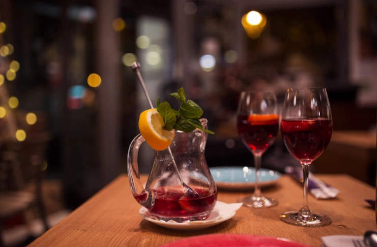 a glases of wine and a pitcher nearby 