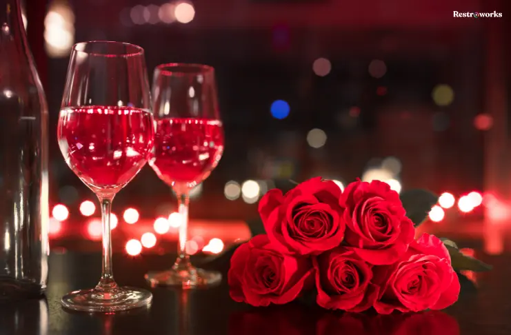 A table with 2 wine glasses and roses