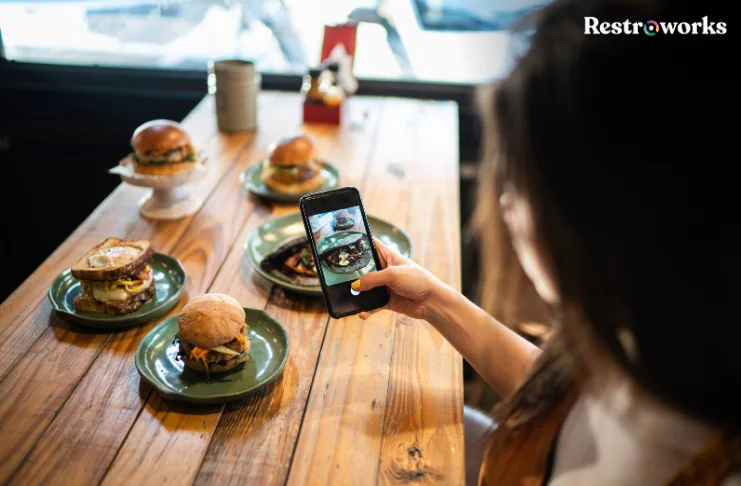 An influencer taking pictures of the restaurant dishes.