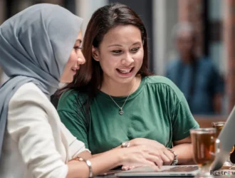 2 women using laptop