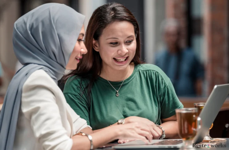 2 women using laptop