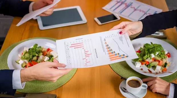 Restaurant staff discussing over analytics metrics